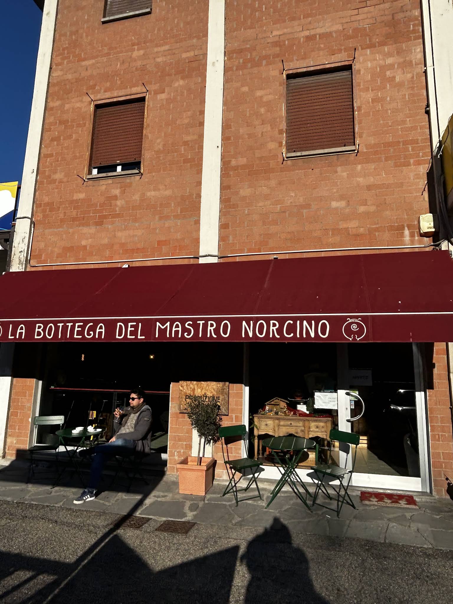 Tenda rossa e ingresso della bottega